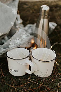 Autumn fall camping mugs with tea. couple drinking hot tea on a forest trail. autumn mugs