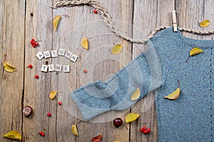 Autumn fall flat lay,Warm knitted sweater, Fall Leaves, chestnuts, rowan berry and pumpkin with inscription `autumn time`