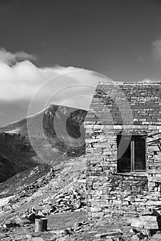 Autumn Fall landscape image of old bothy in Lake Districtr mountains near Buttermere with Haystacks and High Stiel in the distance