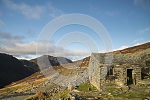 Autumn Fall landscape image of old bothy in Lake Districtr mountains near Buttermere with Haystacks and High Stiel in the distance