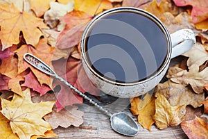 Autumn, fall leaves, hot steaming cup of coffee on wooden table background. Seasonal, morning coffee, Sunday relaxing