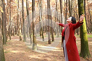 Autumn / fall beautiful woman happy in free freedom pose in autumn park Embrace nature