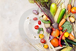 Autumn farm vegetables and root crops on wooden box top view. Healthy and organic food.