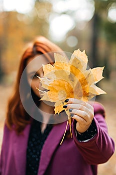 Autumn fashion, earth tones style, bright fall color palette. Portrait of red-haired girl in purple coat