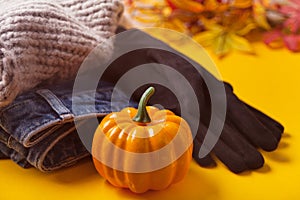 Autumn female outfit. Pile of clothes on the yellow table