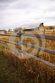 Autumn, fence and old western farm buildings