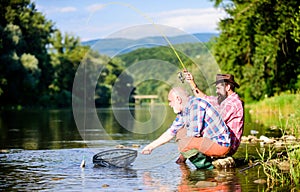 Autumn fishing spinning. Two male friends fishing together. retired dad and mature bearded son. happy fishermen