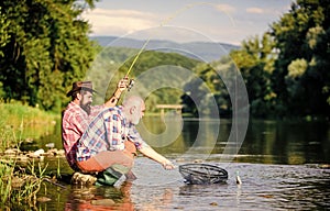 Autumn fishing spinning. Two male friends fishing together. retired dad and mature bearded son. happy fishermen