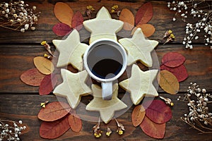 Autumn flat lay on wooden background, a cup of coffee, biscuits, autumn leaves, dried flowers