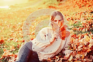 Autumn flirty blonde girl dreamy posing in November day. Outdoor photo of a pleased long-haired woman sitting on the