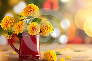 Autumn floral bouquet made of fresh yellow dahlia in vintage red jug on blurred green background with festive bokeh