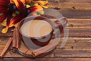 Autumn flower arrangement, cup of coffee with cinnamon and flowers on a wooden table, hyuge style, concept of modern coffee shop