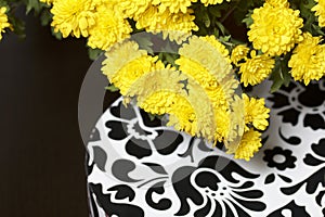 Autumn flowers in a pot. Yellow Chrysanthemum. Next gift in a cardboard box with an ornament. On a gray background.