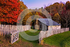 Autumn foliage and rustic cabin in sunset glow