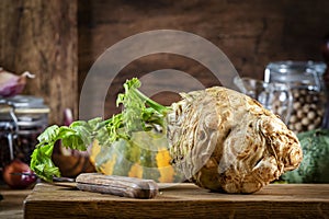 Autumn food cooking background with organic farm vegetables: celery root, pumpkin, herbs and spices on rustic wood kitchen table