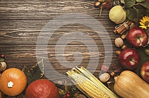 Autumn food top view, Thanksgiving or Halloween background: pumpkins, nuts, fallen leaves and spices on brown wooden background.