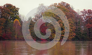 Autumn forest on the bank of the river and its reflection in the water