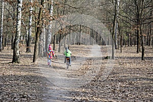 In the autumn forest girl goes next to the boy who travels by bi