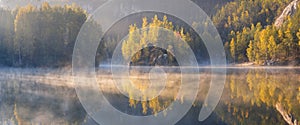 Autumn forest reflected in water. Colorful autumn morning in the mountains.