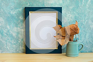 Autumn frame mockup, blue and golden border, tree branch with dry leaves in pitches, bluish concrete wall background, rustic