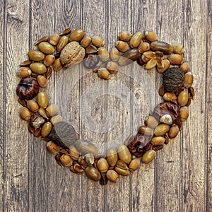 Autumn frame in the shape of a heart on a wooden background