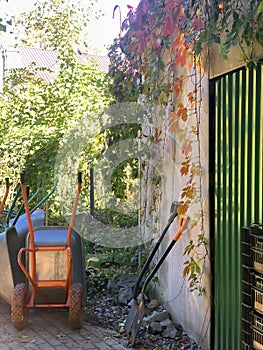 autumn gardening, wheelbarrows, shovels, barn with green door