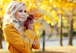 Autumn Girl. Fashion Blonde Beautiful Woman with Maple leaves in