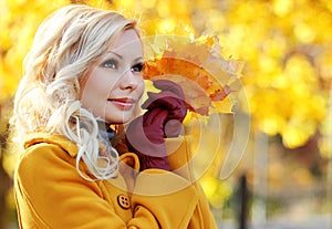 Autumn Girl. Fashion Blonde Beautiful Woman with Maple leaves