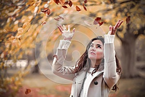 Autumn girl with flying leaves
