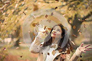 Autumn girl with flying leaves