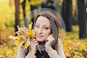 Autumn girl playing in city park. Fall woman portrait of happy lovely and beautiful young woman in forest in fall colors.