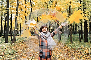 Autumn girl walking in city park. Portrait of happy lovely and beautiful young woman in forest in fall colors.