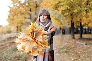 Autumn girl walking in city park. Portrait of happy lovely and beautiful young woman in forest in fall colors. Focus on