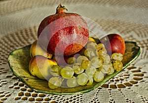 Autumn grape, pomegranate and apple fruits on wool background