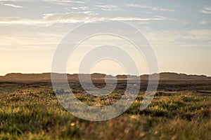 Autumn grass field landscape with dune view  in background