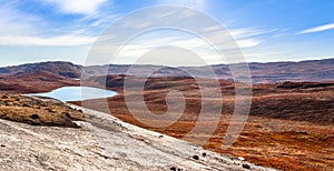 Autumn greenlandic orange tundra landscape with lakes and mountains in the background, Kangerlussuaq