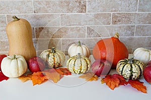 Autumn Halloween or thanksgiving day table setting. Fallen leaves, pumpkins on white wooden table