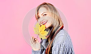 Autumn. Happy woman in warm clothes with yellow leaves. Beautiful girl in knitted sweater and scarf.