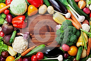 Autumn harvest farm vegetables, root crops and wooden cutting board top view with copy space for text. Healthy food background.