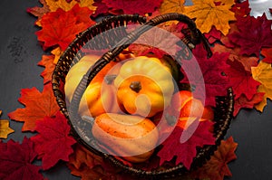 Autumn harvest festivity, Thanksgiving feast and  fall festival concept with pumpkins and squash in a wicker basket on fallen