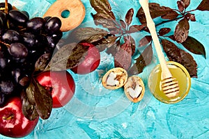 Autumn harvest frame background. Autumn food still life with season fruits grape, red apples and figs on a blue table.