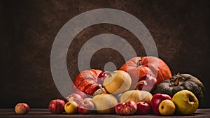 Autumn harvest, happy Thanksgiving day, Halloween. Festive still life with pumpkins and apples on dark  brown background with copy