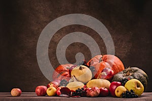 Autumn harvest, happy Thanksgiving day, Halloween. Festive still life with pumpkins and apples on dark  brown background with copy