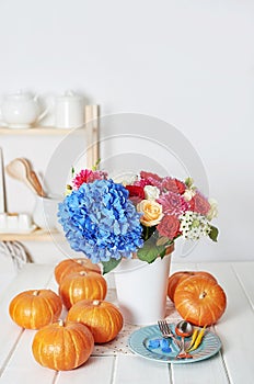 Autumn harvest pumpkin background. Pumpkins and flowers on table. Thanksgiving table. Copy space. Halloween or seasonal autumnal.