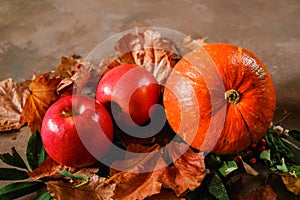 Autumn harvest. Pumpkin, red apples and autumn leaves. Autumn still-life.