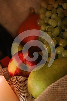 Autumn harvest still life. Fresh fruits: apple, pears, grapes and pumpkin on a sackcloth. Happy thanksgiving