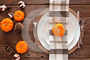 Autumn harvest or thanksgiving dinner table setting, top view on a rustic wood background