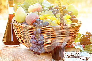 Autumn harvest in wicker basket and red wine