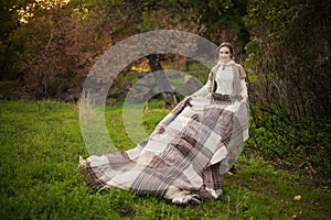 Autumn holiday. Young woman holds plaid