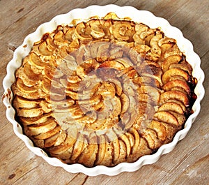 Autumn homemade apple pie - charlotte. on white ceramic plate on wooden background with fresh apples